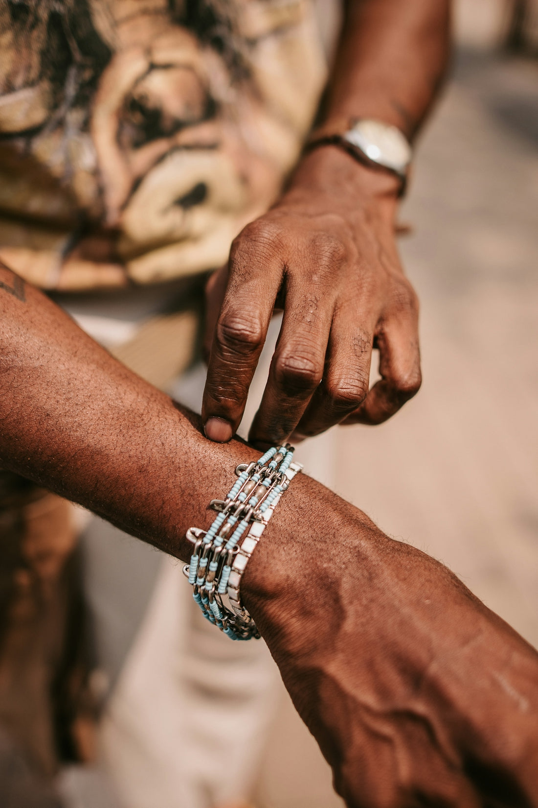two people holding hands with bracelets on their wrists