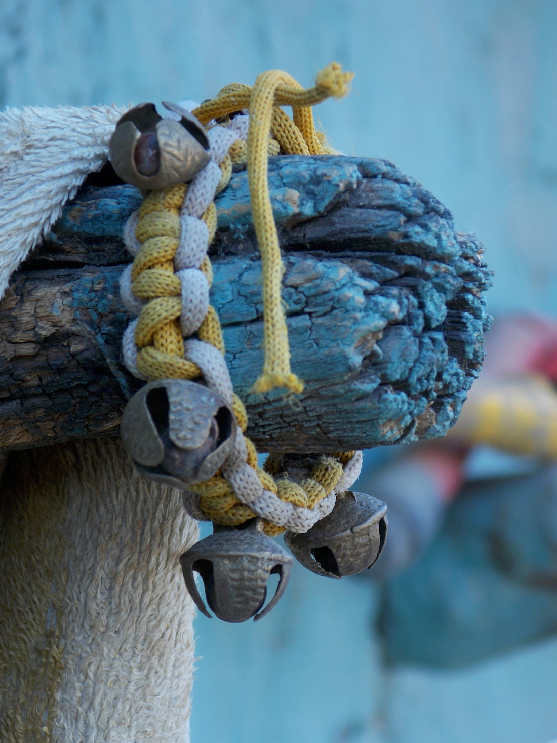 A decorative bracelet with bells hangs on wood