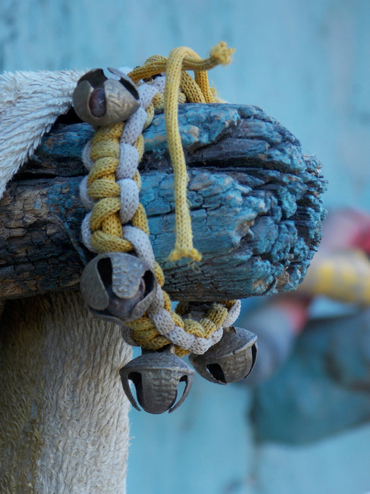 A decorative bracelet with bells hangs on wood
