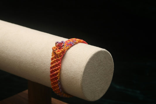 A colorful woven bracelet on display stand